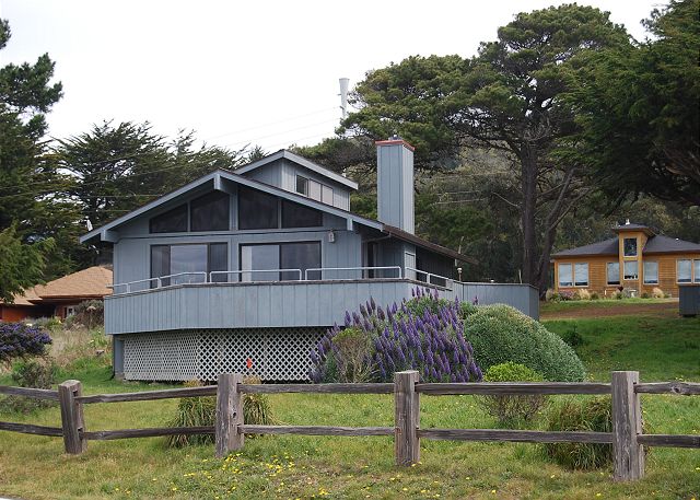 Blue home with deck and small wooden fence