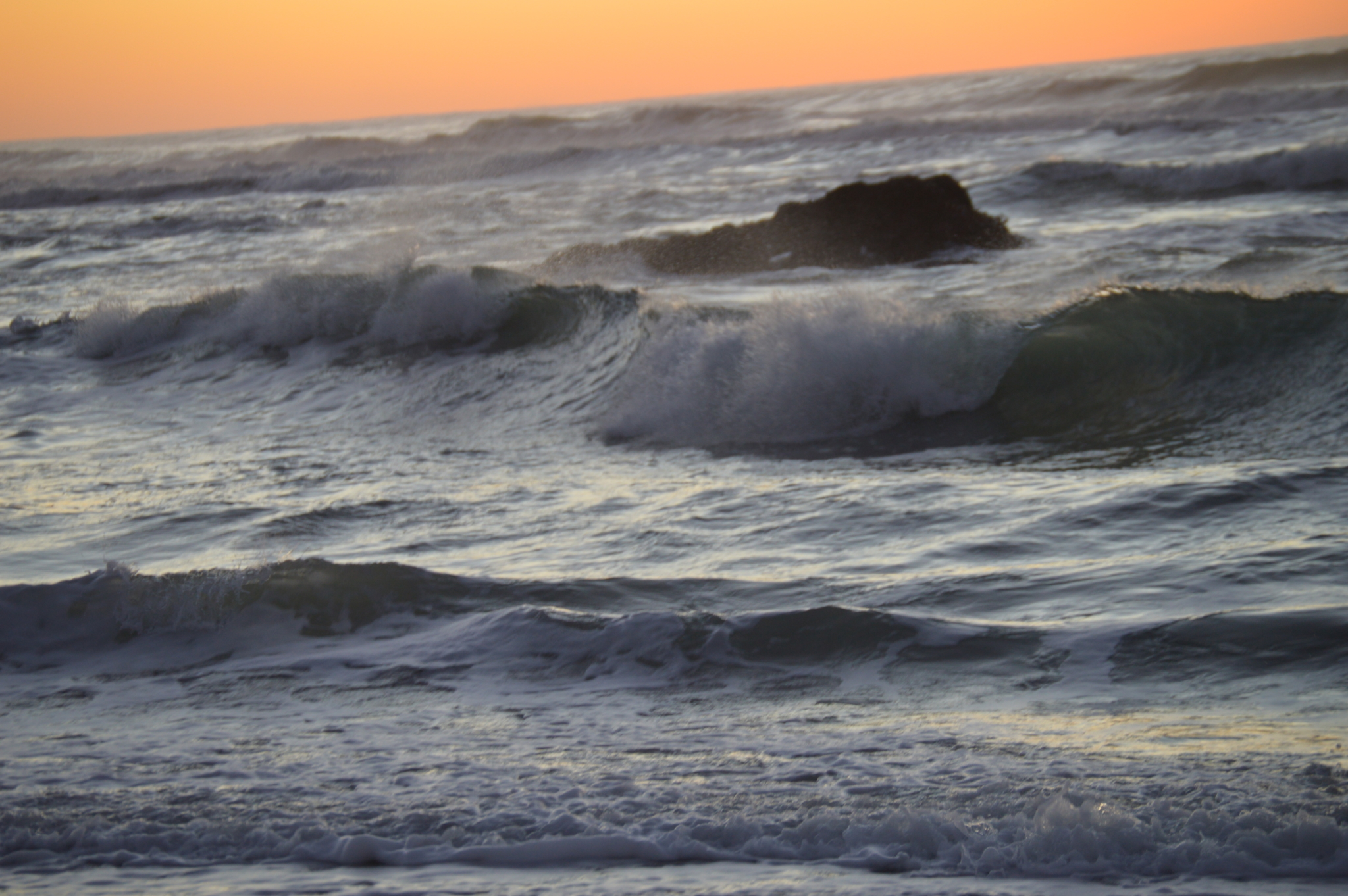 Rolling ocean waves at sunset